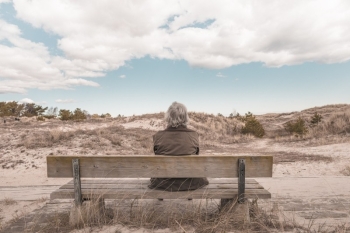 Senior person alone on bench Photo via VisualHunt